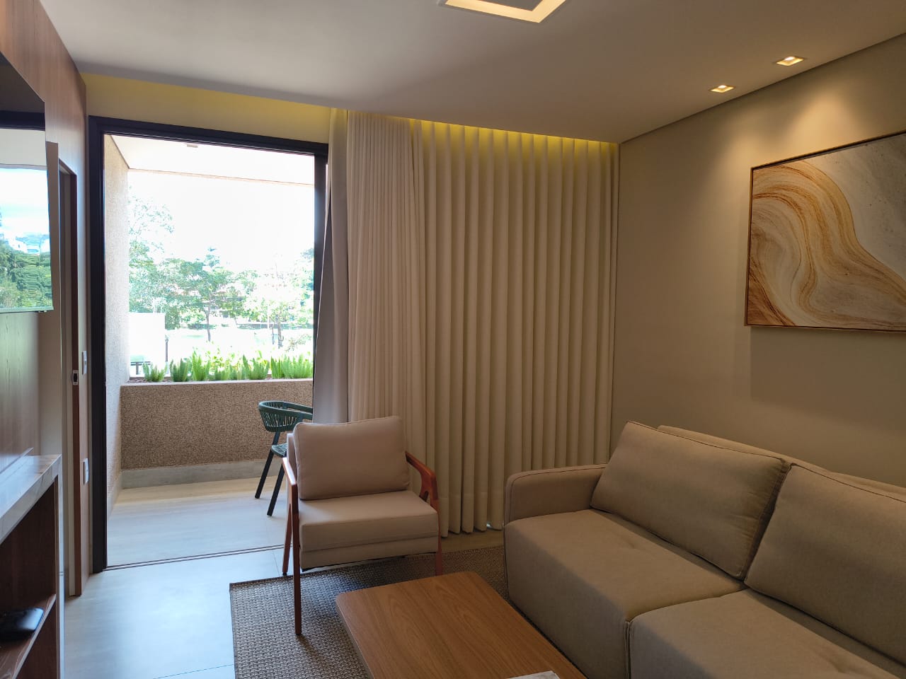 Sala de estar da suíte com varanda e vista para o jardim no Píer 135